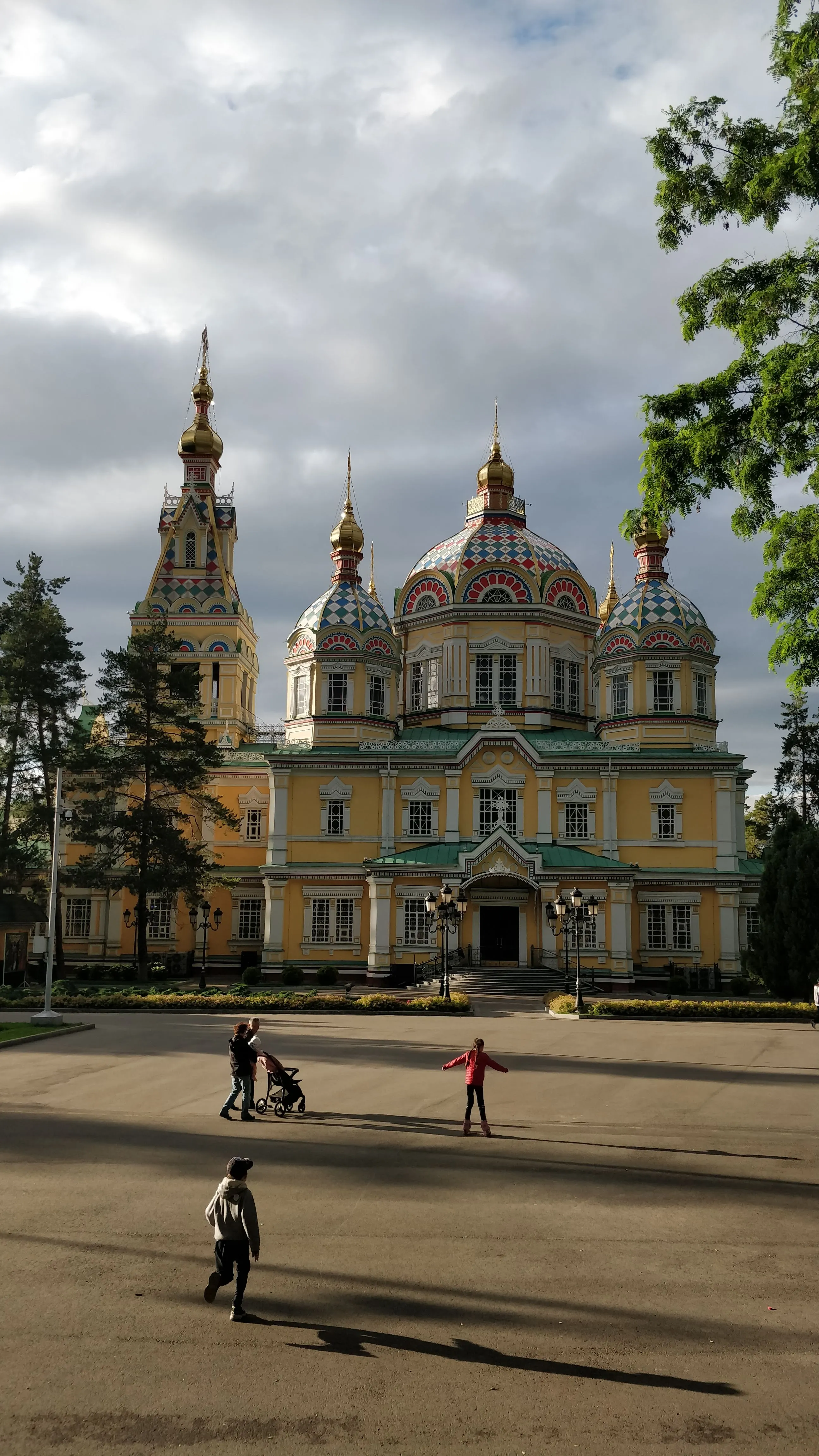 The timber Ascension Cathedral with its gold onion domes above Panfilov Park