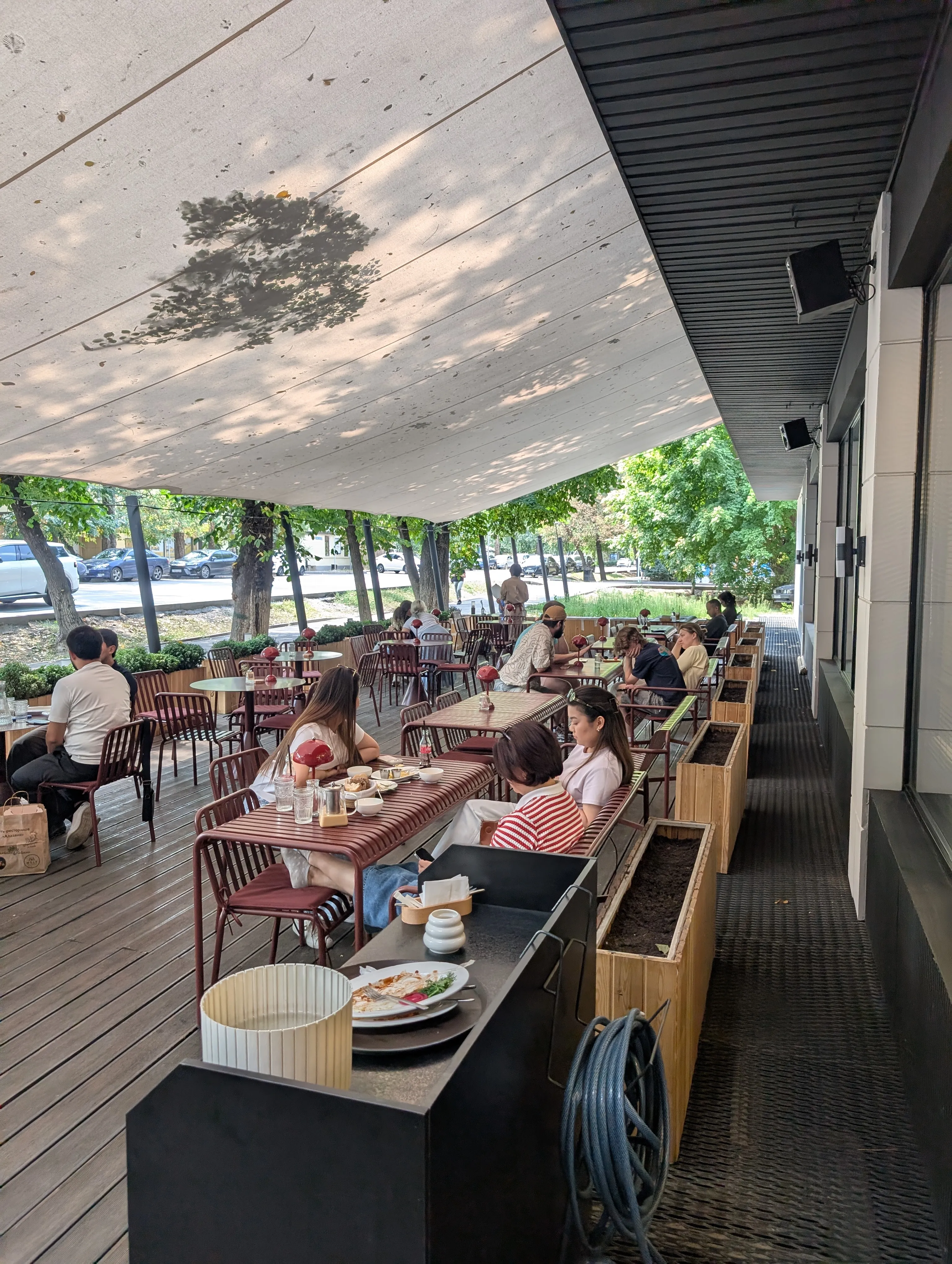 The covered terrace at Bal on Zhambyl, busy with people eating under trees