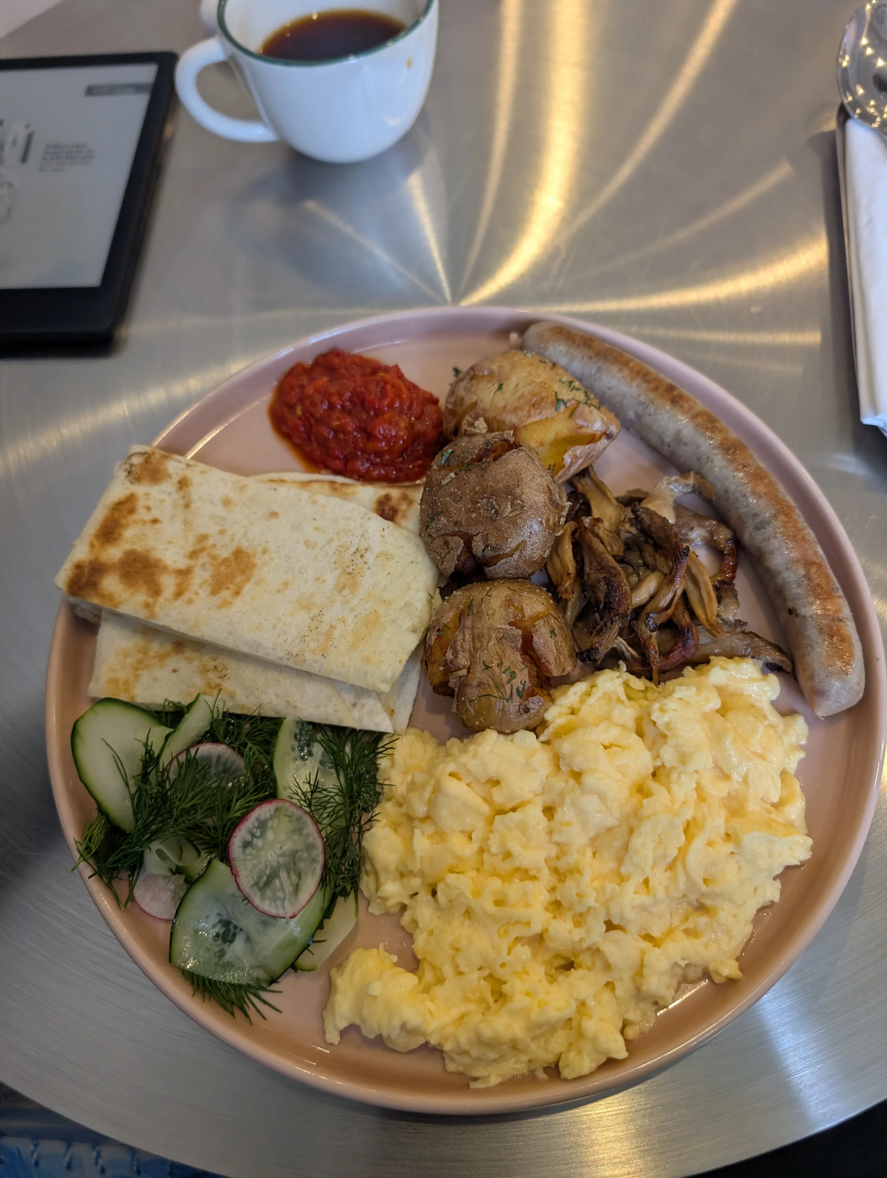 A breakfast plate at Collab: scrambled eggs, sausage, roast potatoes, mushrooms and a cucumber salad
