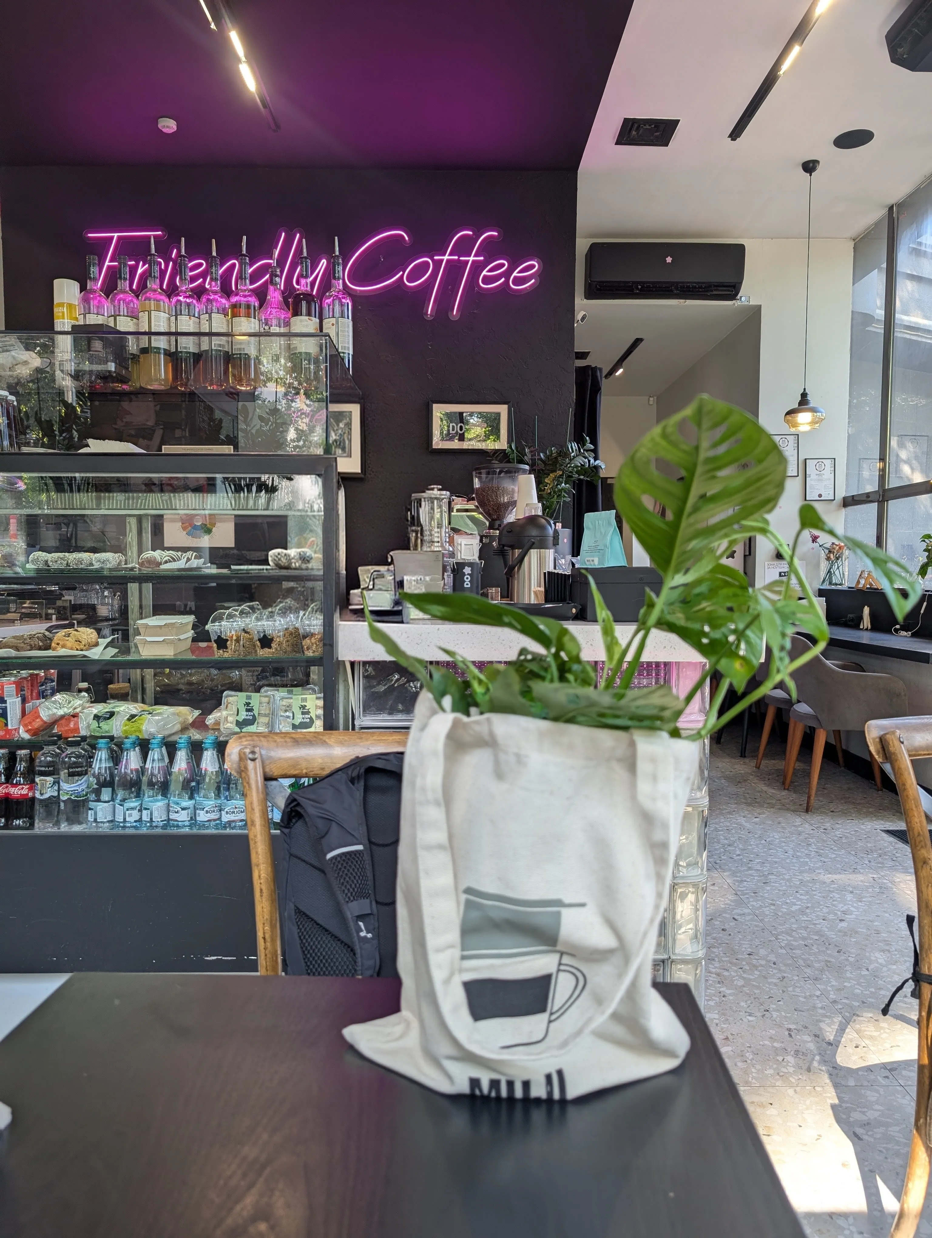 The counter at Do.Star under a pink neon sign, with the pastry case and syrup bottles