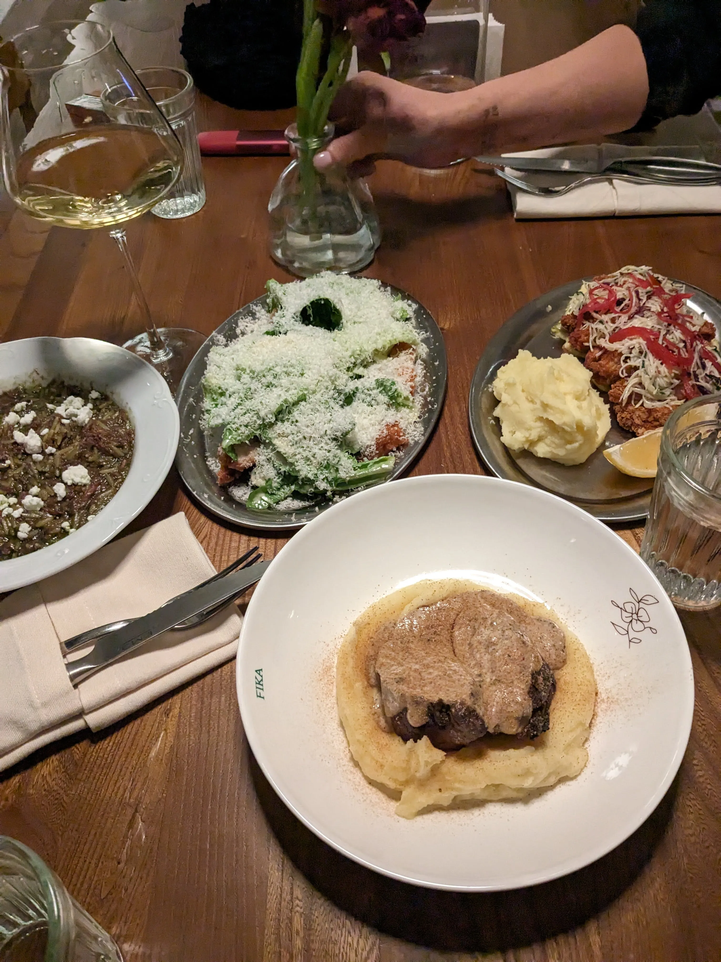 Dinner at Fika: meat in cream sauce over mashed potato, a grated Caesar salad, fried chicken with slaw, and green beans with feta