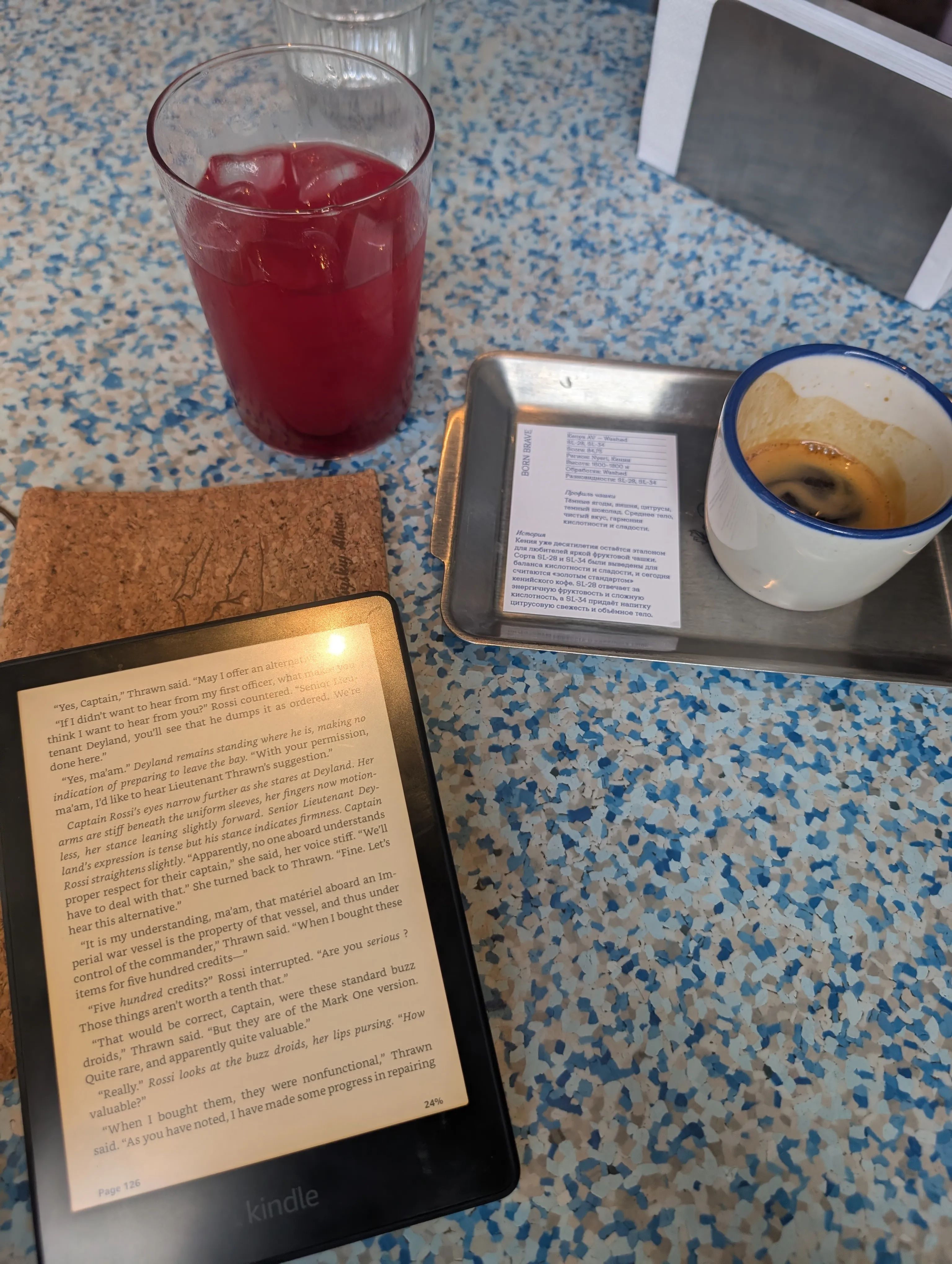 An espresso, an iced berry drink and a bean information card on the table at Fika