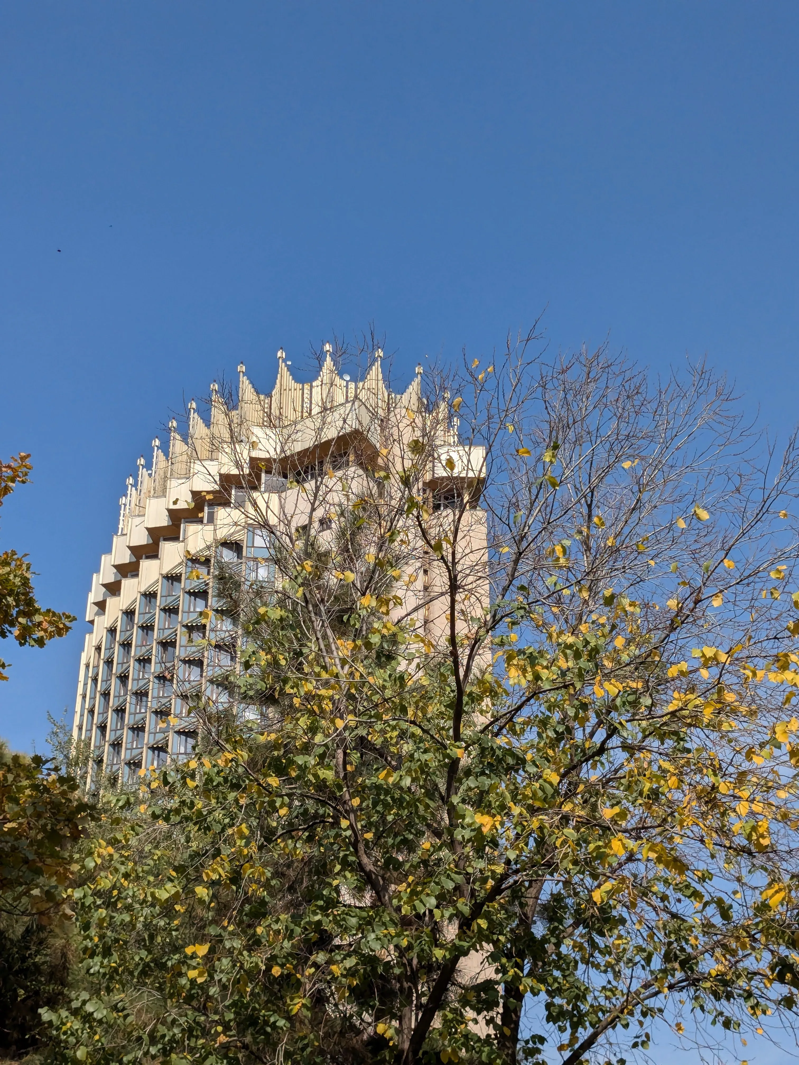 The gilded crown of the Hotel Kazakhstan against a bright sky