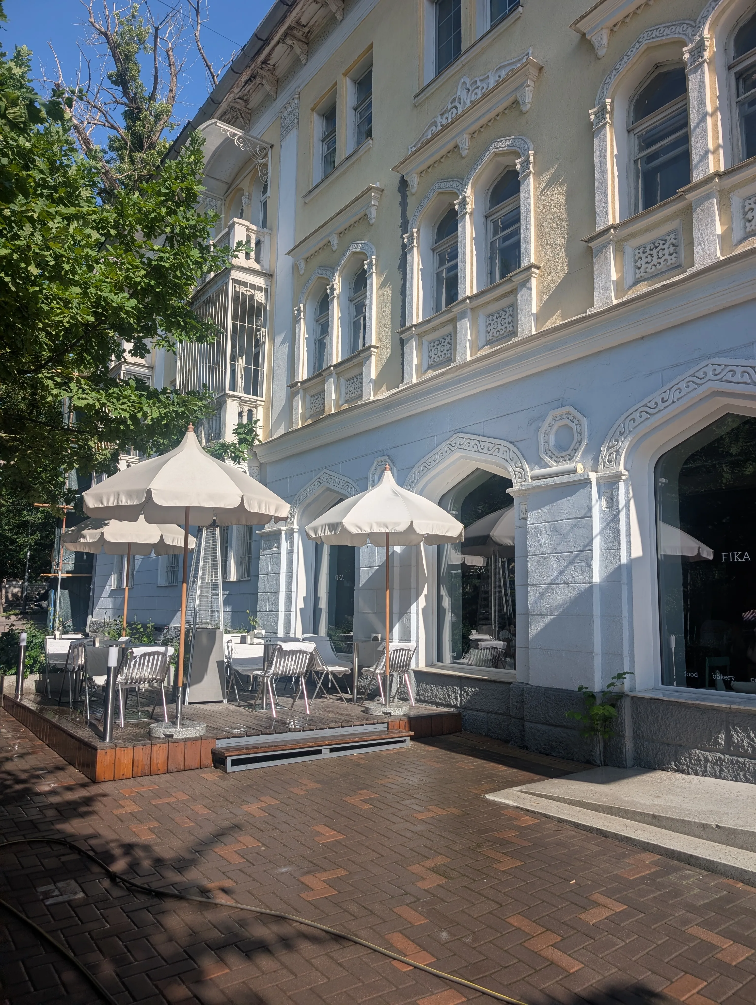 The pale blue and cream facade of the Turksib House with its white plaster arches
