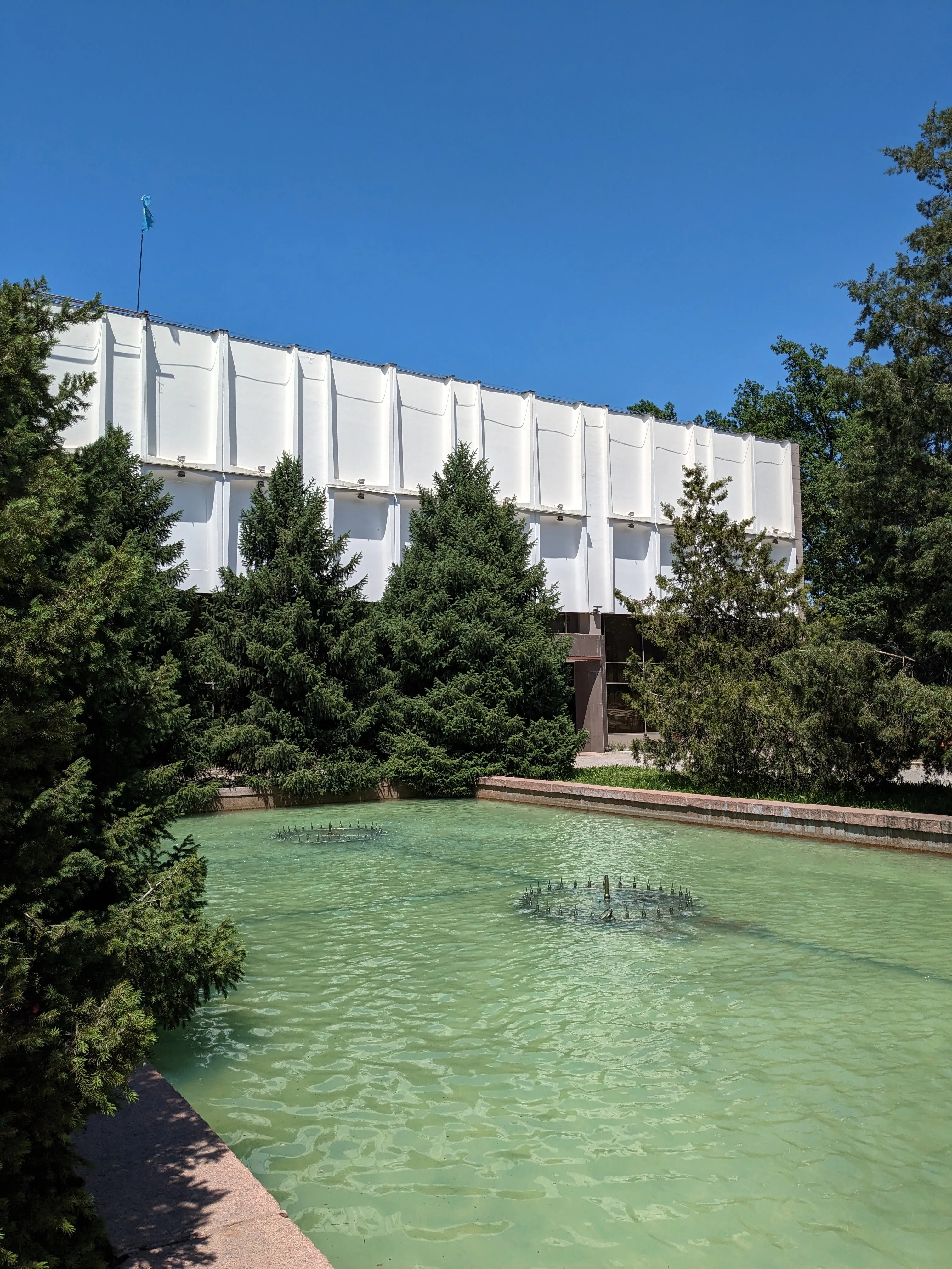The folded white concrete upper tier of the Lermontov theatre above its pool