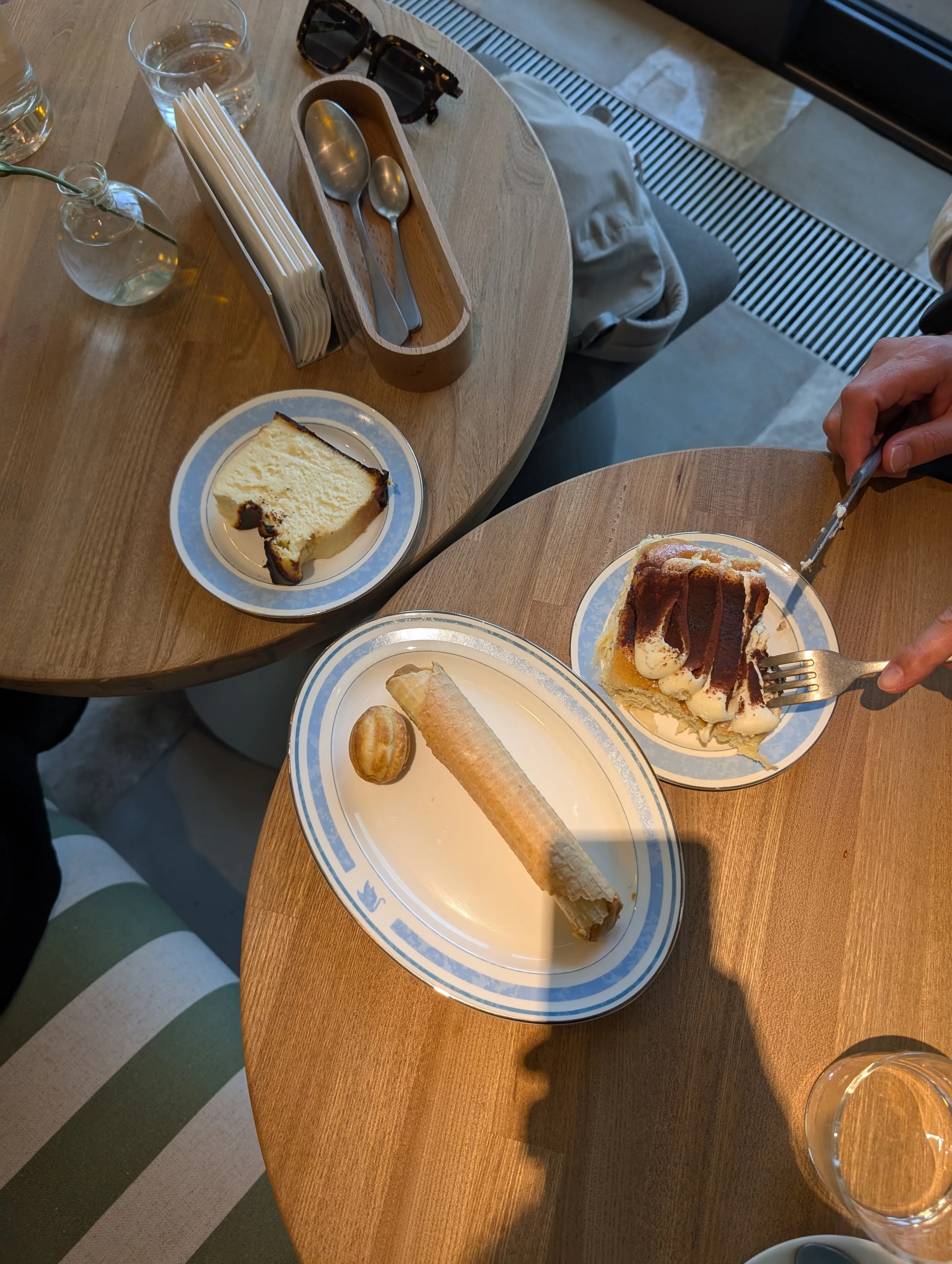 Two pastries at Akku, a slice of layered honey cake and a tiramisu with a cannoli, a fork in each