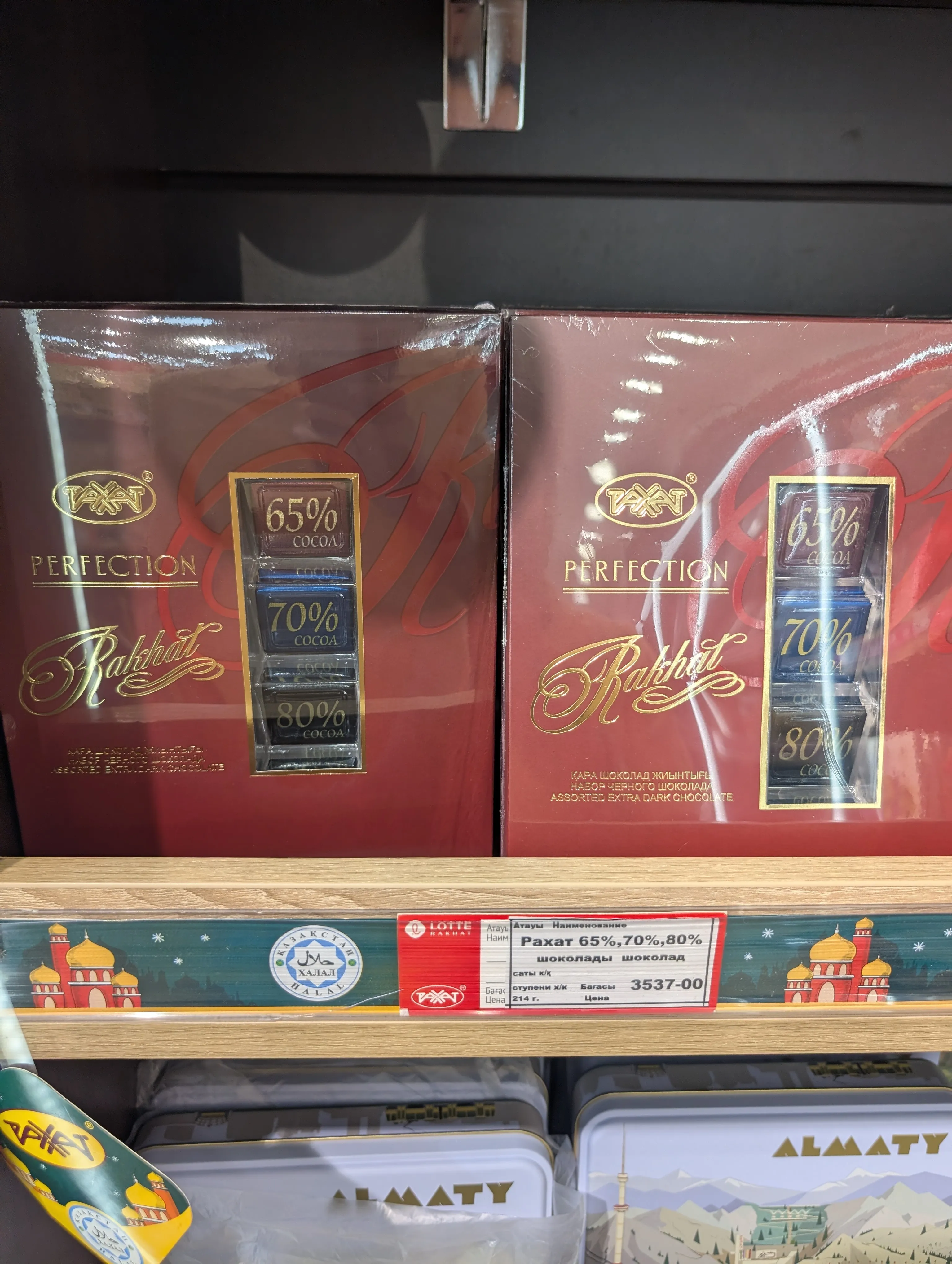 Two burgundy Rahat Perfection gift boxes showing 65%, 70% and 80% cocoa bars through a window, above a tag reading 'Рахат 65%,70%,80%' at 3537 tenge