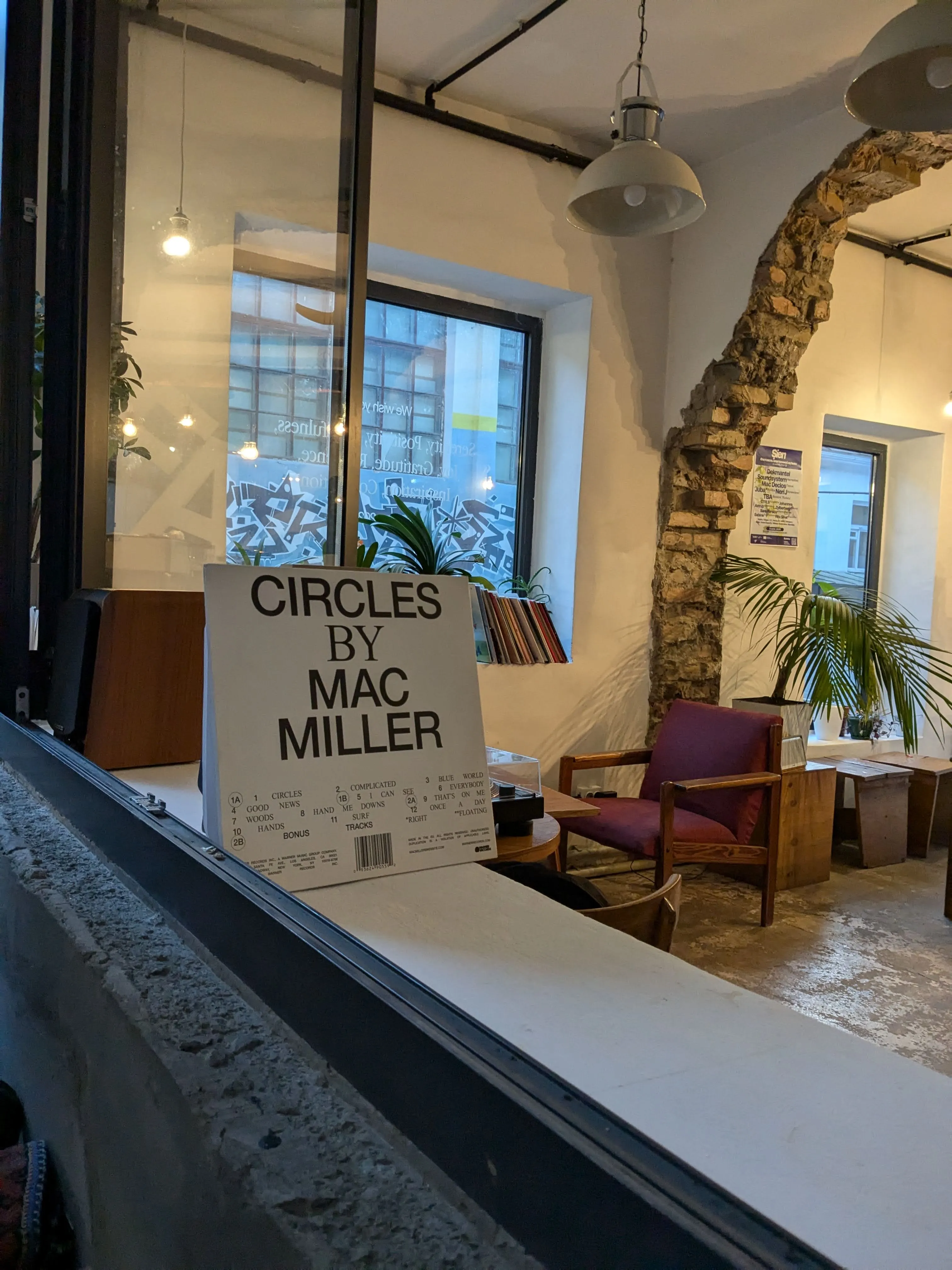 Flask in the evening, a Mac Miller record propped on the counter under a single pendant lamp