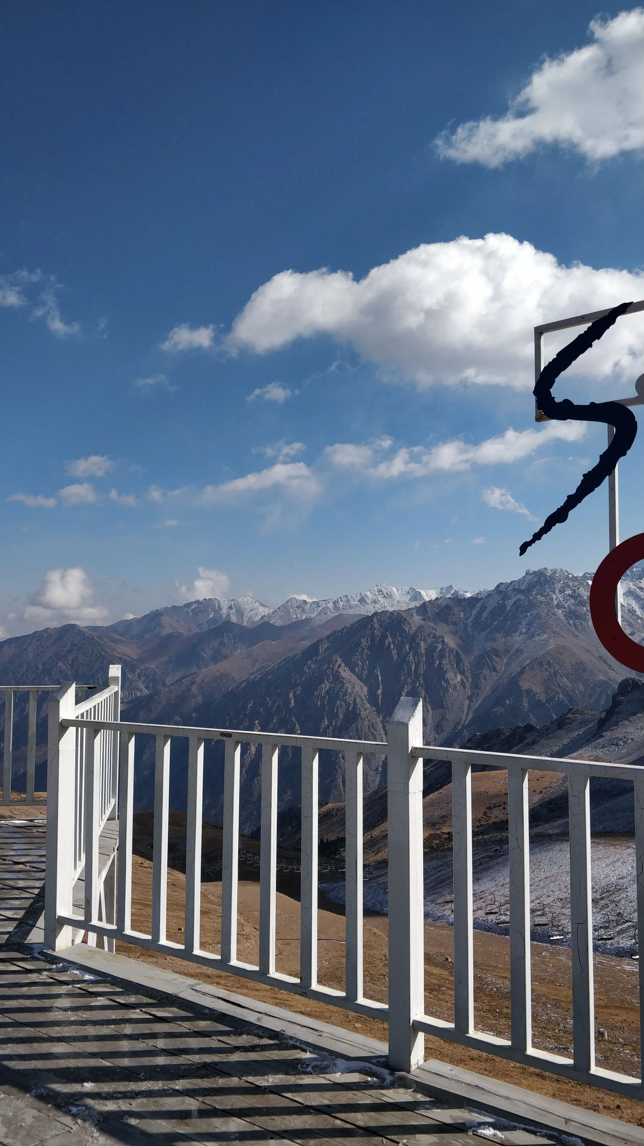 The viewing platform at 3,200 metres, its white railing in the foreground and range after range of mountains beyond