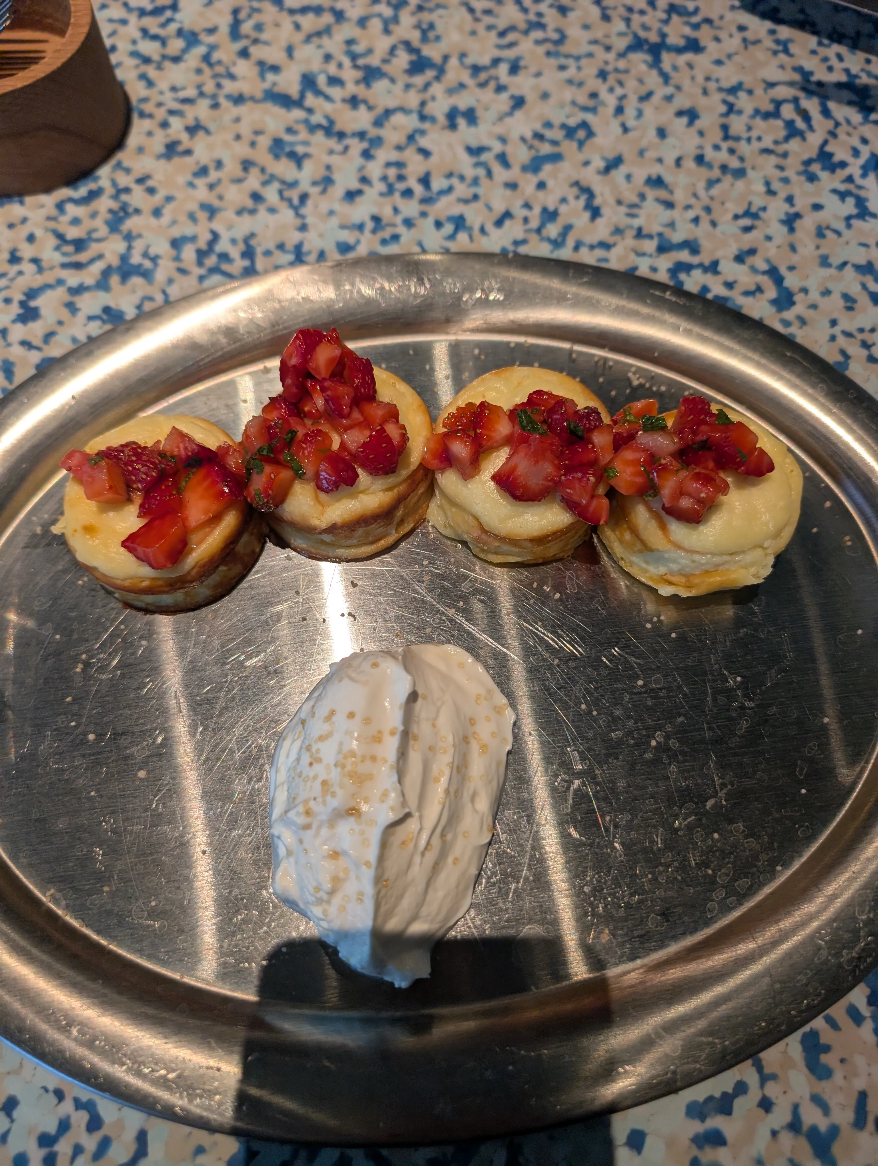 Four syrniki with strawberries and mint, with sour cream, at Fika