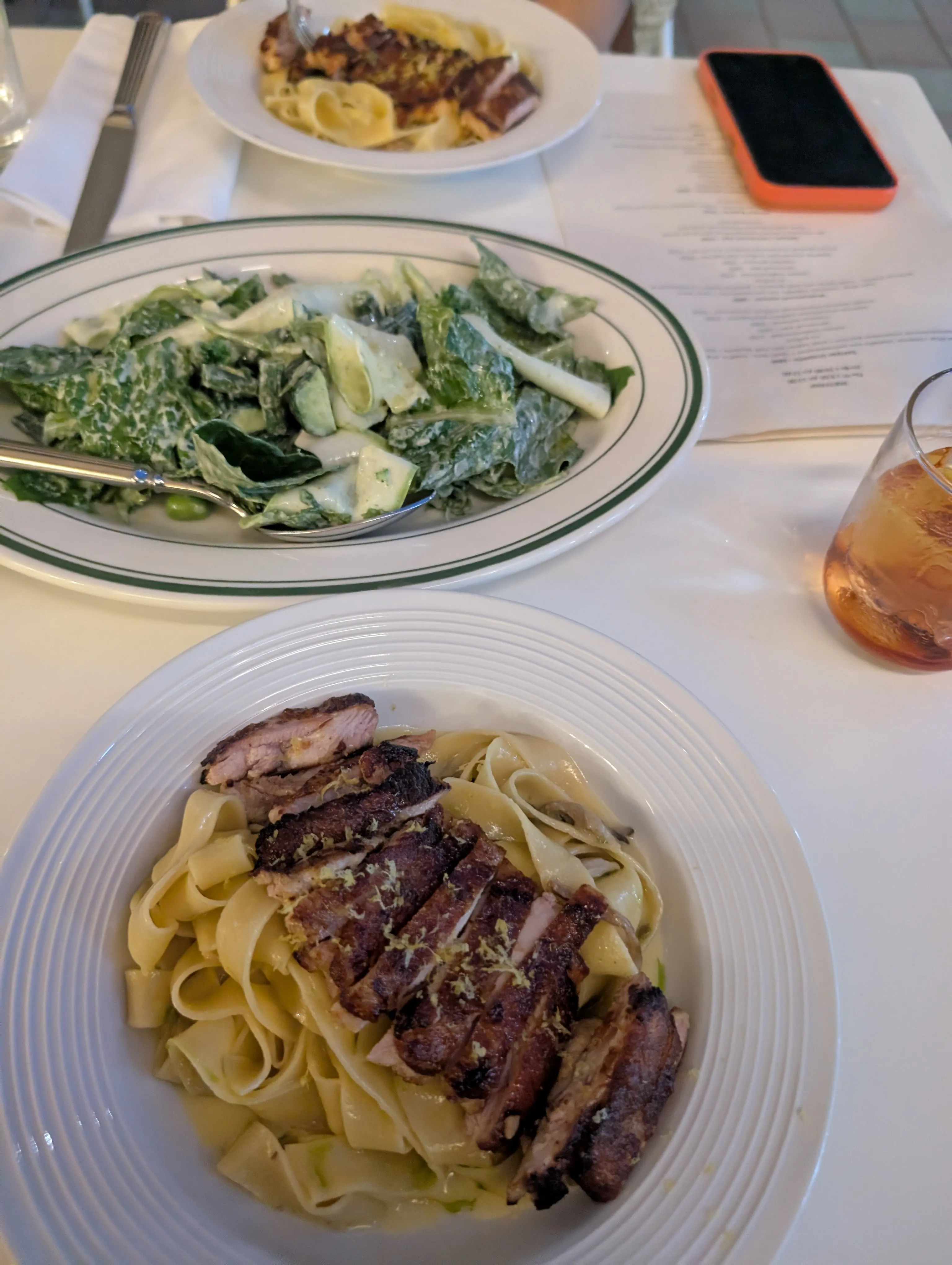 Tagliatelle with sliced duck breast at Unapasta, a grated green salad and a glass of rosé on the table beside it