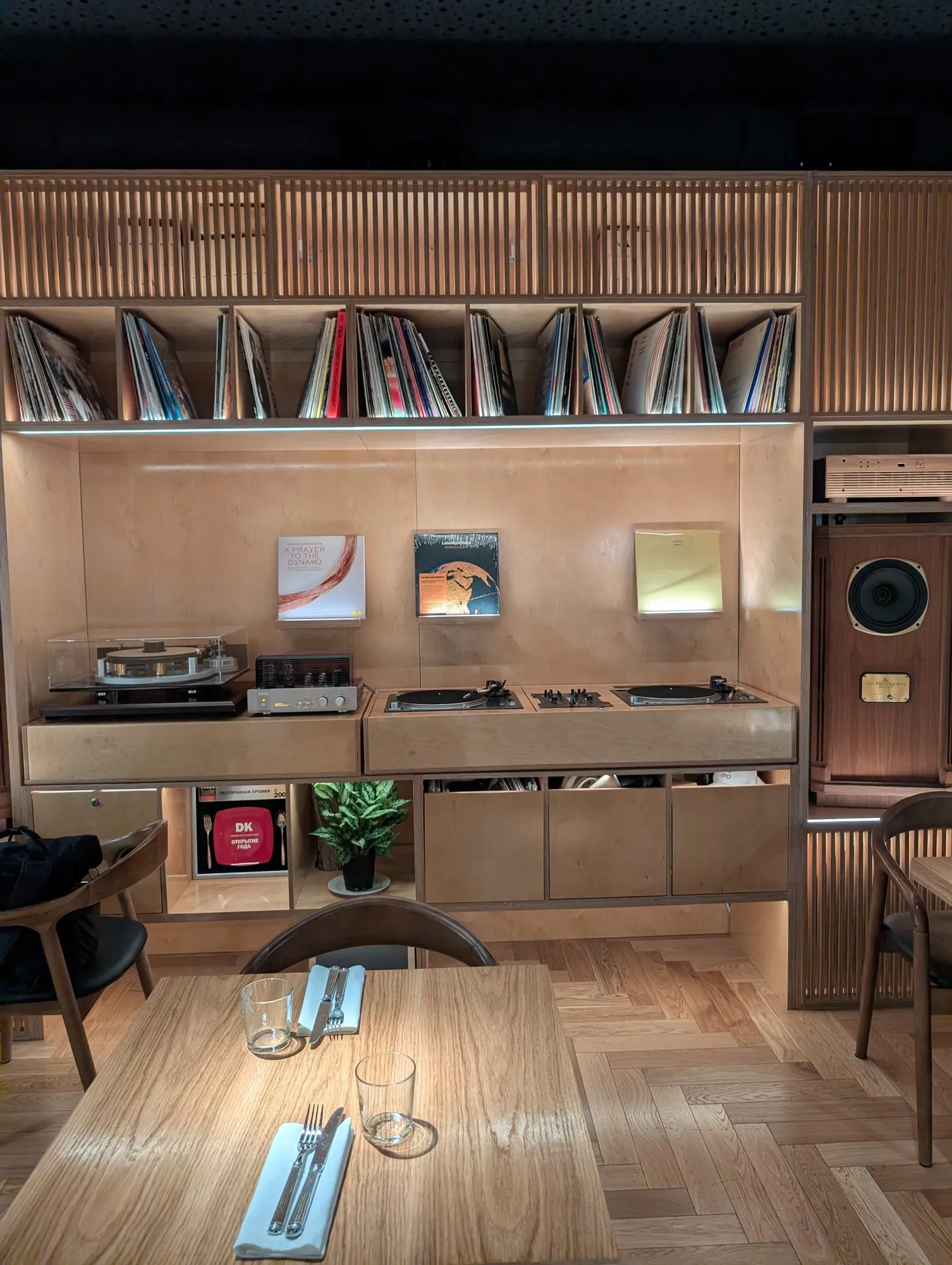 The record wall at Unapasta: shelved LPs above two turntables and a mixer, a valve amplifier and a large wooden speaker cabinet