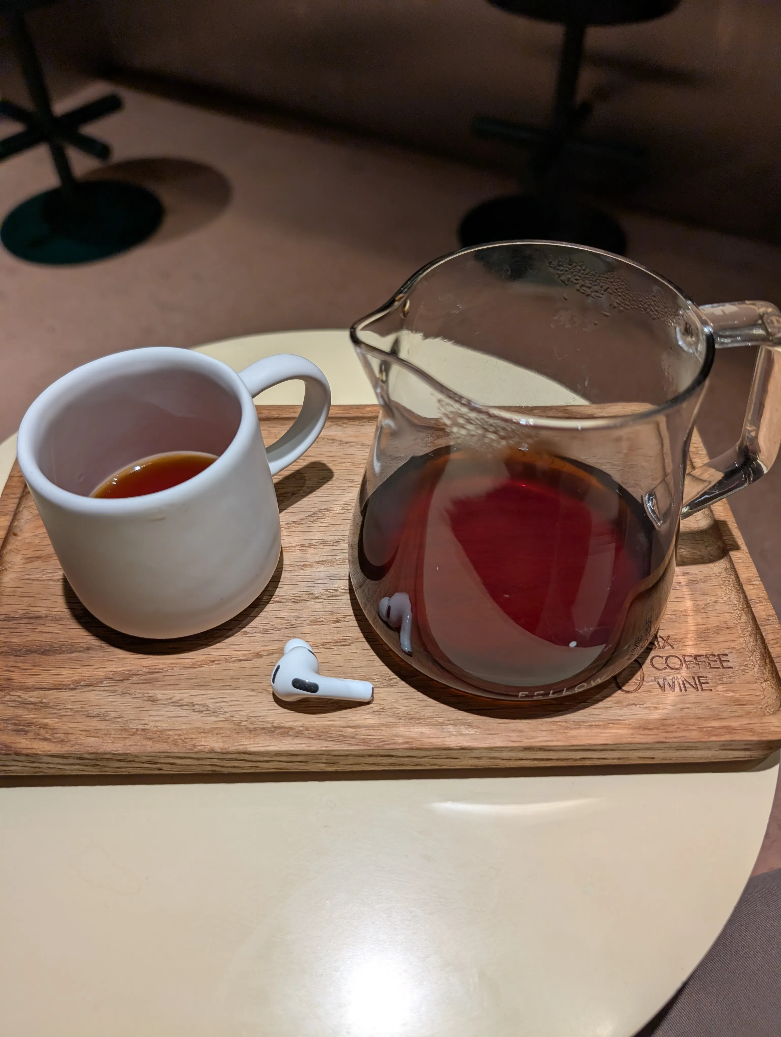 A glass server of filter coffee and a cup on the branded board at Six Bogenbay